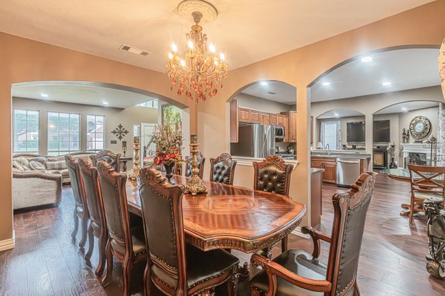 Dining room with arched walkways, a chandelier, and dark wood-type flooring | Image 14