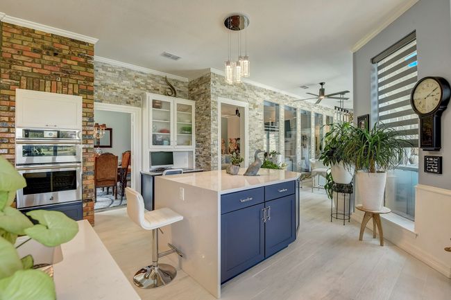 Kitchen offers a custom island with waterfall quartz countertops | Image 8