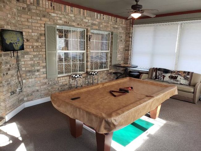 Playroom with carpet floors, brick wall, ceiling fan, and billiards | Image 27
