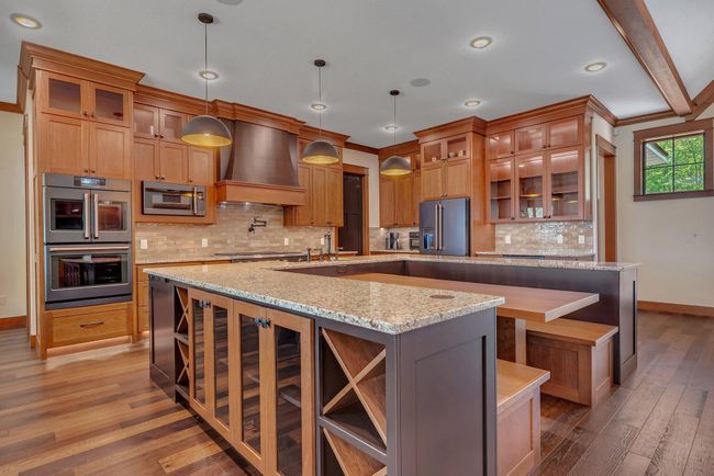 Kitchen center island featuring a built-in wine holder. | Image 36