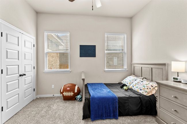 Carpeted bedroom with multiple windows, ceiling fan, and a closet | Image 19