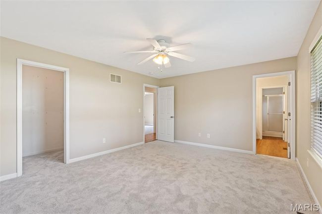 Unfurnished bedroom featuring carpet floors, baseboards, a closet, and a walk in closet | Image 14