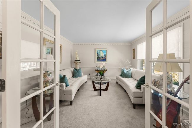 Carpeted living area with crown molding, french doors, and baseboards | Image 9