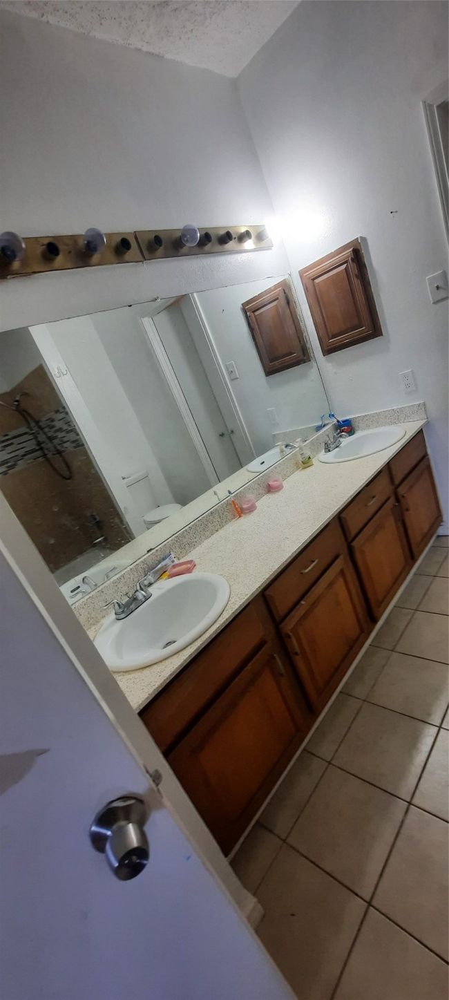 Bathroom with double vanity, tile patterned flooring, and a sink | Image 8