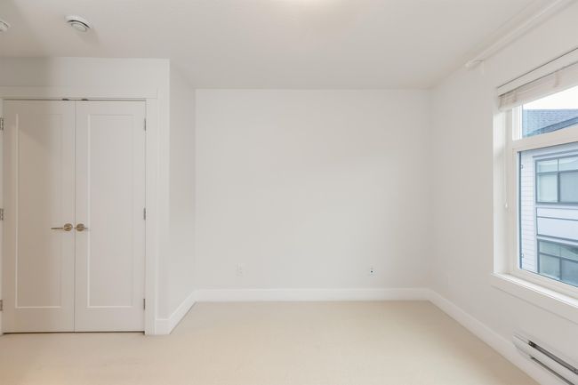 Empty room with baseboard heating, light carpet, and baseboards | Image 25