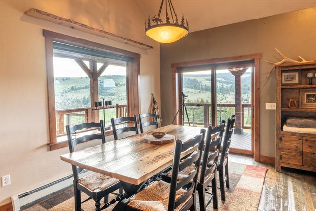 Dining area featuring a baseboard radiator, plenty of natural light, light wood-type flooring, lofted ceiling, and baseboards | Image 9