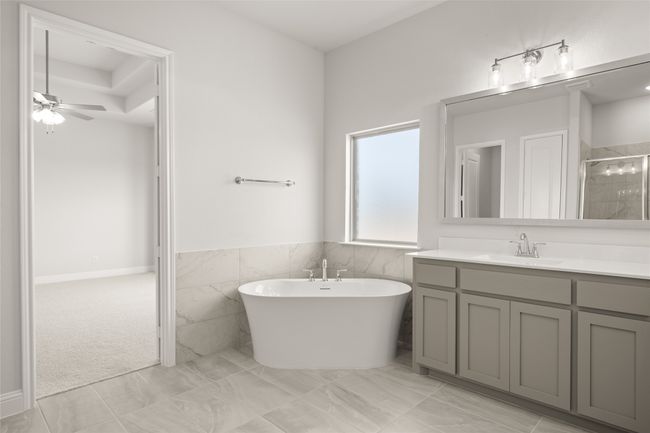 Full bath with vanity, a stall shower, a freestanding tub, a ceiling fan, and wainscoting | Image 17