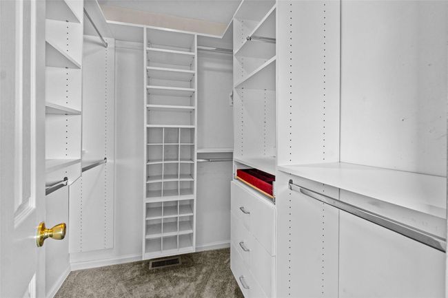 Walk in closet featuring dark colored carpet | Image 24