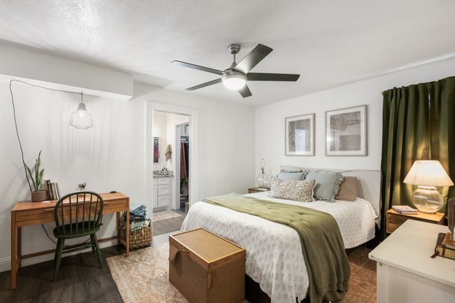 Bedroom featuring dark wood-style flooring, ceiling fan, and ensuite bath | Image 17