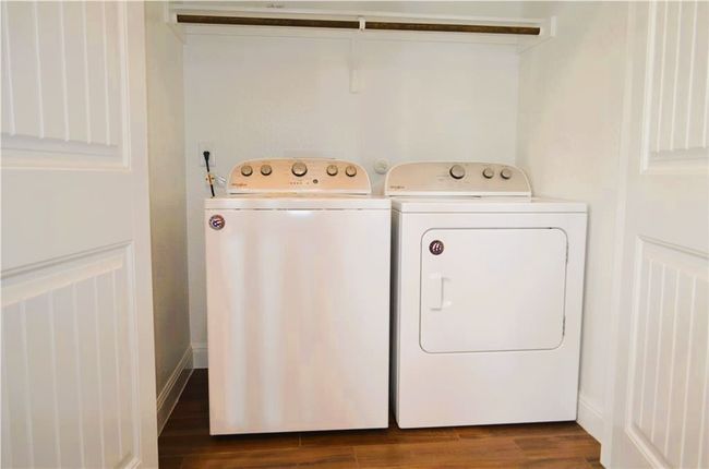 Laundry area with washing machine and dryer and dark wood-style floors | Image 9
