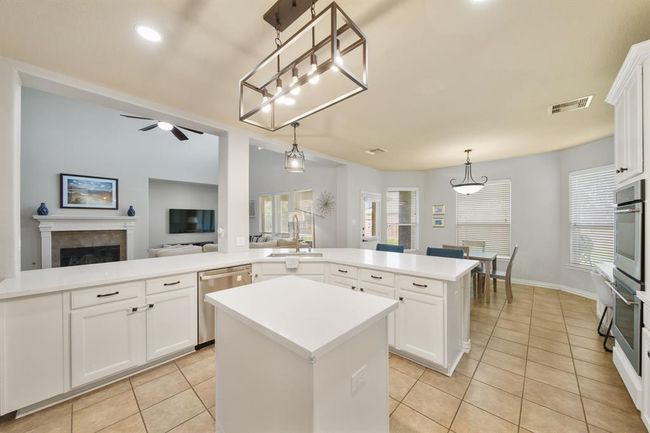 Imagine preparing your favorite meals & recipes in this thoughtfully planned kitchen as your family & friends circulate about the wraparound serving bar and nearby living spaces! | Image 18