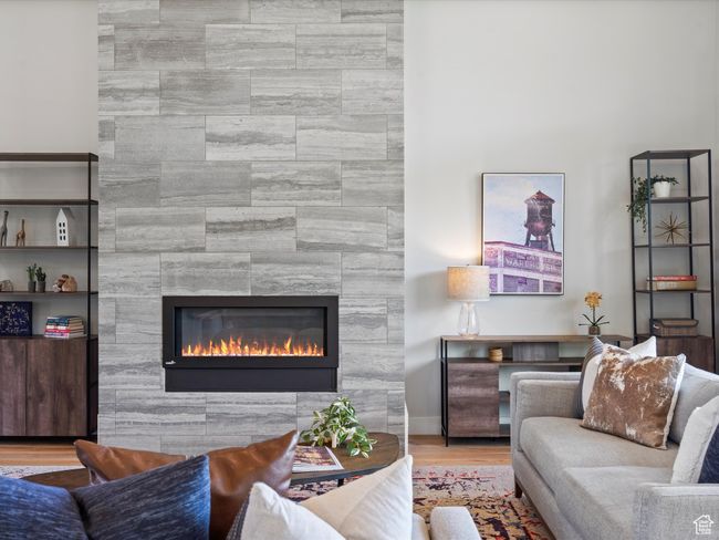 Living room featuring a tiled fireplace and wood finished floors | Image 11