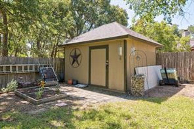 View of outbuilding featuring a garden, an outdoor structure, and a fenced backyard | Image 36
