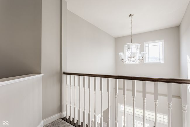 stairs with baseboards and a notable chandelier | Image 36