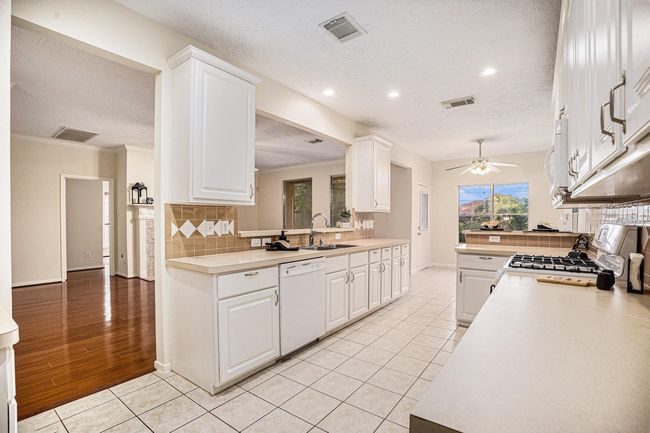 Long gally kitchen with lots of storage space. | Image 14