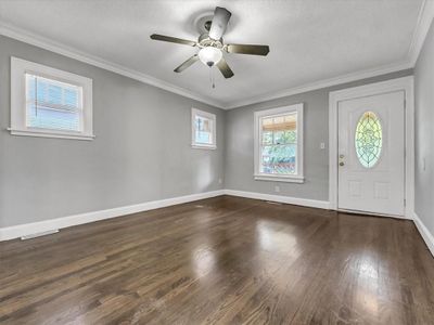 Entryway featuring dark hardwood / wood-style floors, crown molding, a textured ceiling, and ceiling fan | Image 2