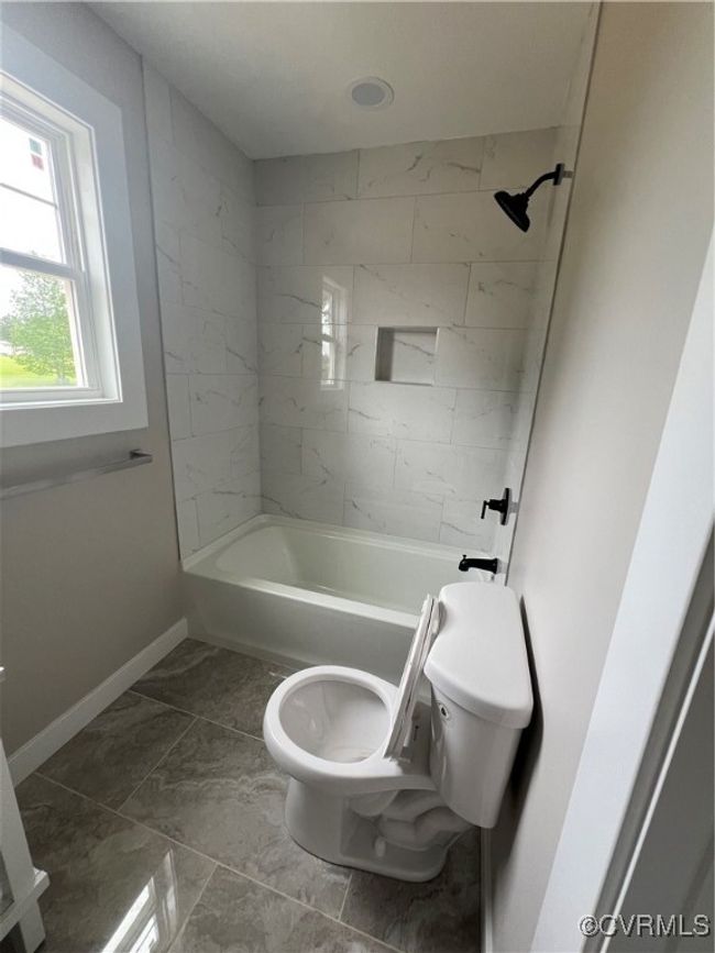 Bathroom featuring shower / bathing tub combination, toilet, baseboards, and marble finish floor | Image 21
