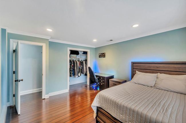 Bedroom featuring recessed lighting, wood-type flooring, ornamental molding, baseboards, and visible vents | Image 12