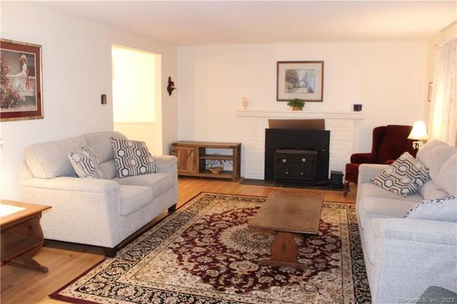Living room has a fireplace with wood stove insert. | Image 11