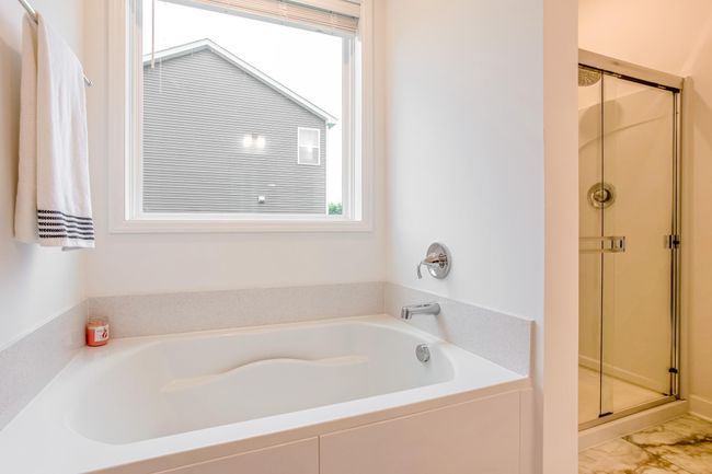 Relax in the deep soaking tub beneath natural light or refresh in the adjacent glass-enclosed shower. | Image 21