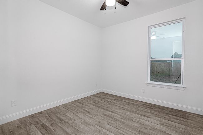 Spare room featuring a ceiling fan, wood finished floors, and baseboards | Image 15