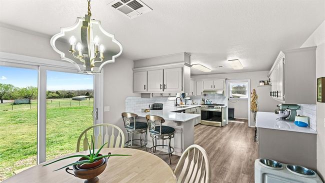 Dining room featuring visible vents, a chandelier, and light wood-style floors | Image 40