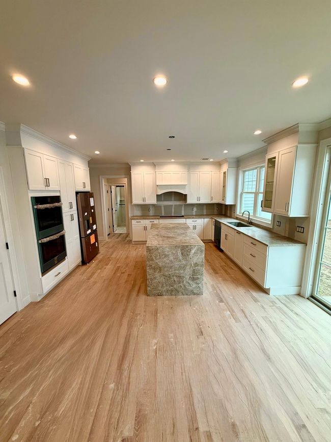 Kitchen with crown molding, light wood-type flooring, recessed lighting, stainless steel appliances, and a center island | Image 4