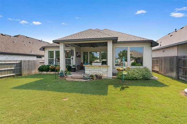 Back of house with ceiling fan, a shingled roof, stucco siding, and a patio | Image 34