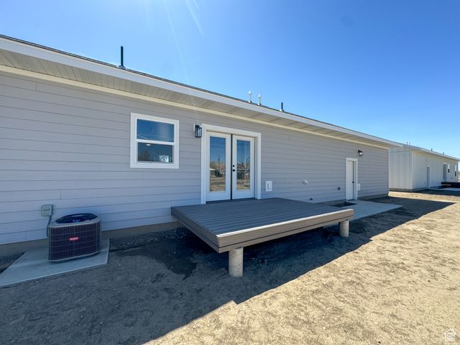 Rear view of house featuring a deck, french doors, and central AC | Image 40