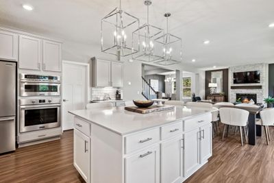 (Photo of model home, finishes will vary) The spacious kitchen features a large center island, quartz countertops, recessed lighting, under mount sink, LVP floors, stainless appliances and more! | Image 3