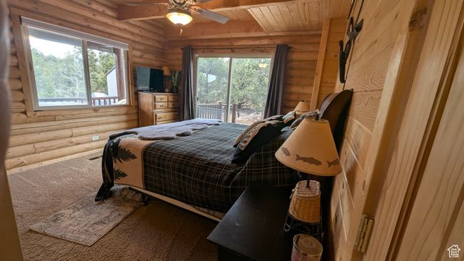 Bedroom featuring log walls, ceiling fan, wood ceiling, and carpet floors | Image 17