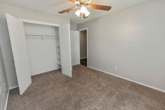 Unfurnished bedroom featuring carpet floors, a closet, a ceiling fan, and baseboards | Image 22
