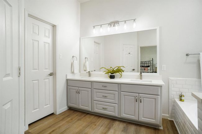 Bathroom featuring double vanity, a tub to relax in, and wood finished floors | Image 16