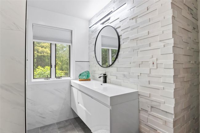 Bathroom featuring vanity, tile walls, decorative backsplash, and tile patterned floors | Image 22