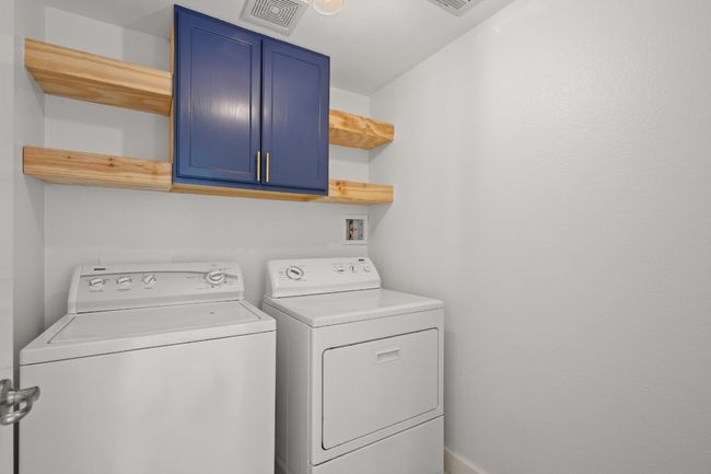 Washroom featuring cabinet space and washing machine and dryer | Image 24
