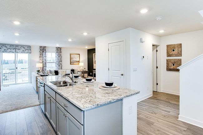 The kitchen looks out to the large deck located off the family room. Model picture shown. Colors and finishes may vary. Subject address is an interior unit. Exterior unit photos shown. | Image 4