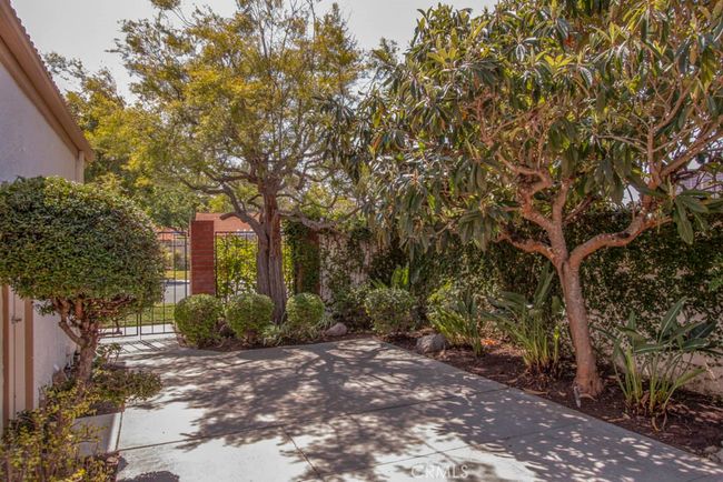 Front courtyard is beautifully landscaped with trees and birds of paradise. | Image 4
