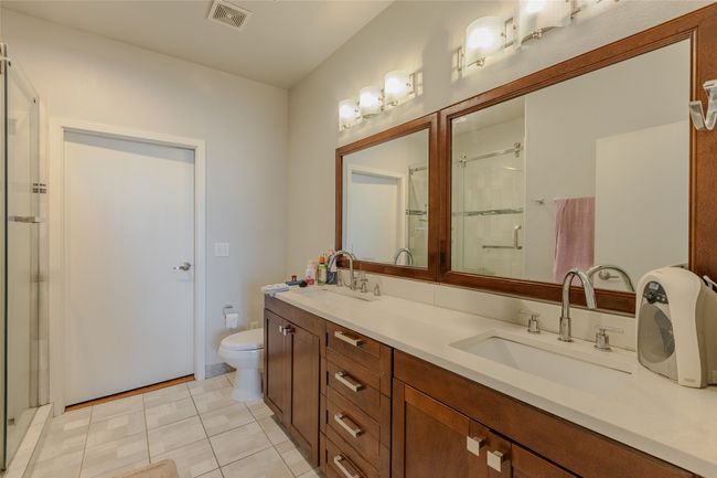 Full bathroom with a shower stall, double vanity, and tile patterned floors | Image 19