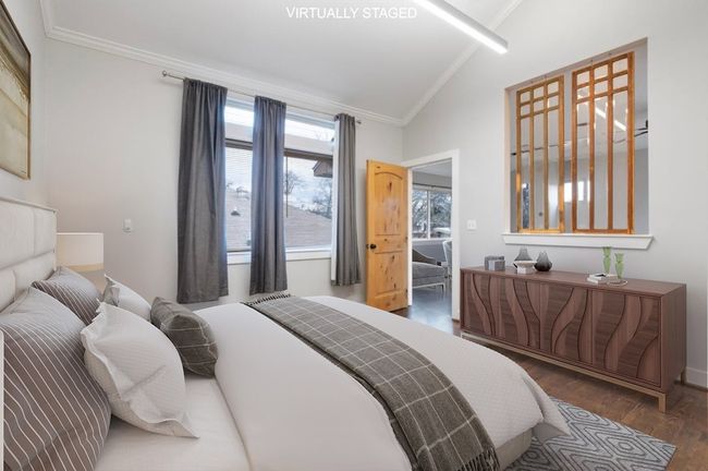 Bedroom with vaulted ceiling, ornamental molding, and wood finished floors | Image 35