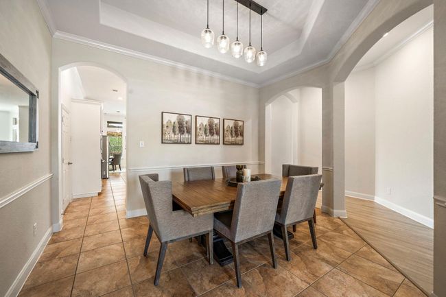 Discover a formal dining room characterized by abundant natural light and sophisticated elegance. The open layout, highlighted by tile flooring, offers ample space for entertaining, making it an ideal backdrop for both intimate dinners and festive gatherings. | Image 23