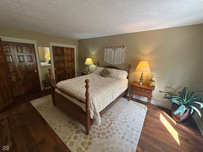bedroom with a textured ceiling, hardwood / wood-style floors, and baseboards | Image 29
