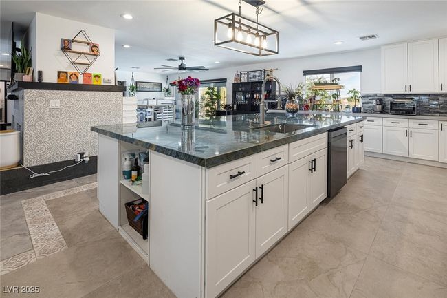 Kitchen with visible vents, a center island with sink, a sink, white cabinetry, and dishwasher | Image 14