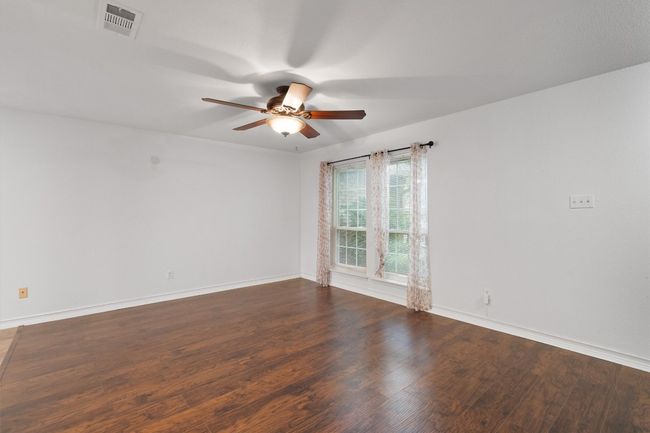 Unfurnished room featuring a ceiling fan and dark wood finished floors | Image 9