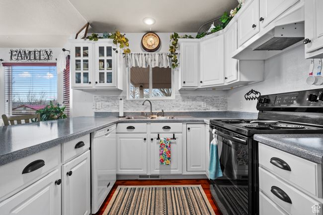 Kitchen featuring a sink, white cabinetry, dishwasher, and black / electric stove | Image 9