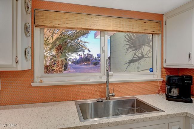 Kitchen with white cabinets, decorative backsplash, and light stone countertops | Image 19