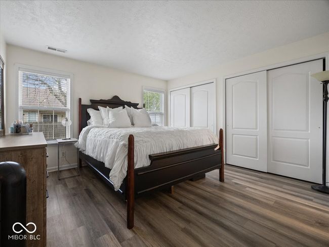 Primary bedroom with hardwood finished floors, and two closets & private bathroom. | Image 12