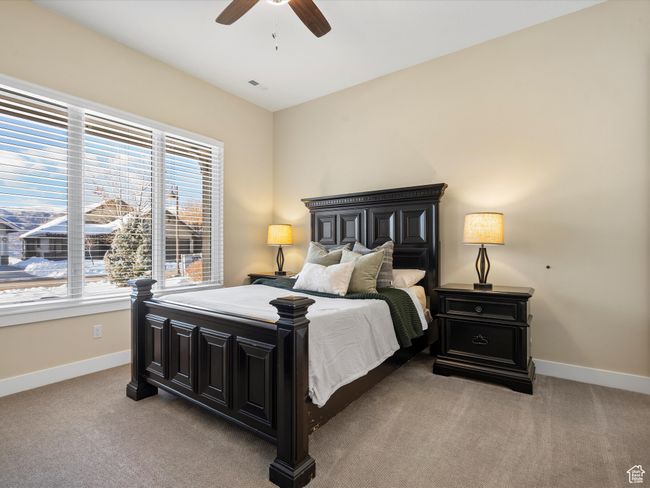 Bedroom featuring multiple windows, baseboards, light carpet, and a ceiling fan | Image 22