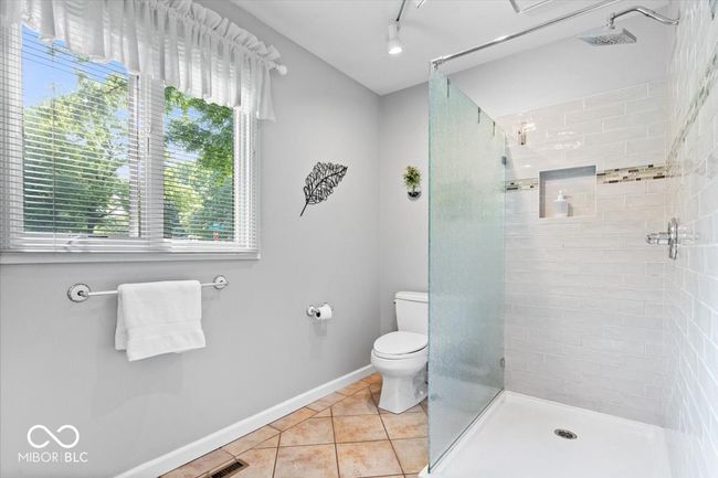 full bathroom with a tile shower and tile patterned floors | Image 21