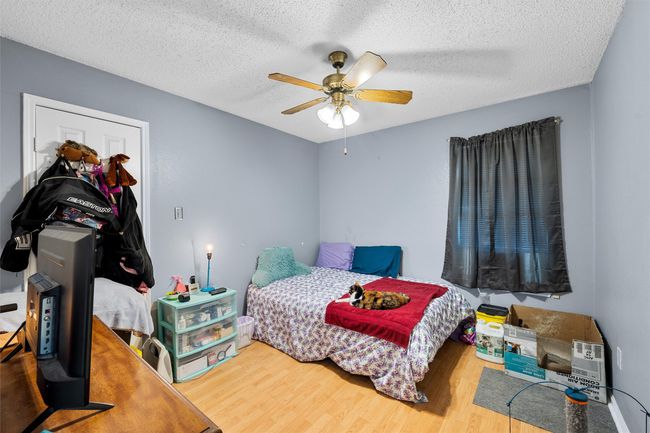 Bedroom with wood finished floors, a textured ceiling, and a ceiling fan | Image 14