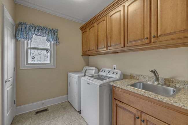 Laundry room with sink, closet, and custom cabinets. | Image 27